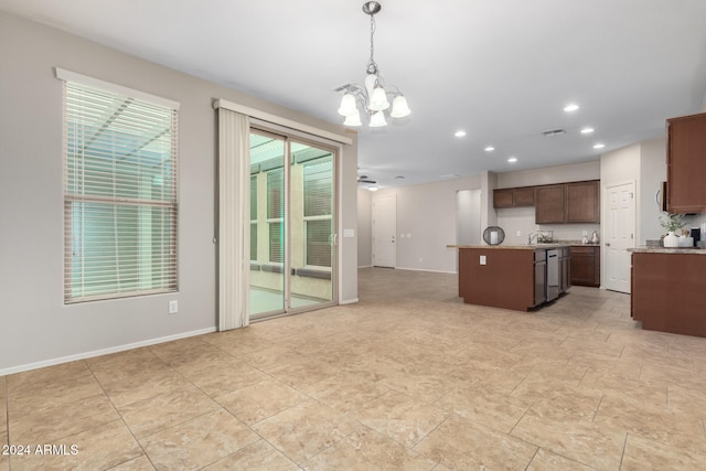 kitchen featuring stainless steel dishwasher, decorative light fixtures, a kitchen island, dark brown cabinetry, and a chandelier