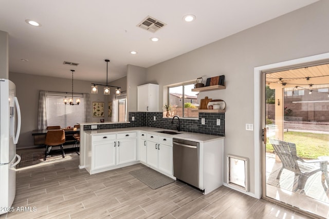 kitchen with dishwasher, fridge, sink, hanging light fixtures, and white cabinets