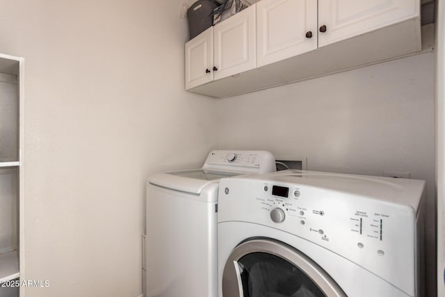 washroom featuring washer and dryer and cabinets