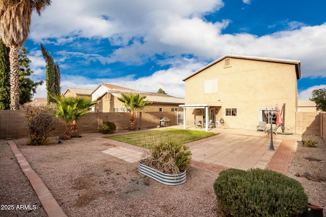 rear view of property with a yard and a patio