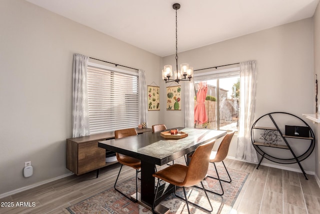 dining space featuring light hardwood / wood-style flooring and a chandelier