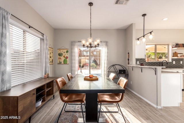 dining area with plenty of natural light, sink, and a chandelier