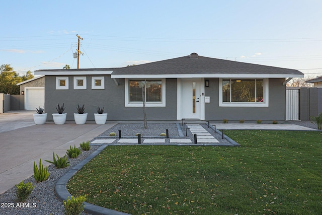 single story home featuring a front yard, an outbuilding, and a garage