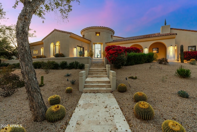 mediterranean / spanish-style home with a tile roof and stucco siding