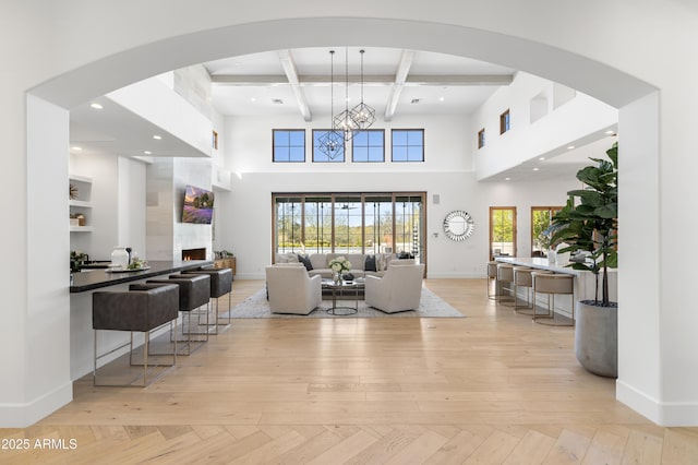 living area with a healthy amount of sunlight, beamed ceiling, coffered ceiling, and baseboards