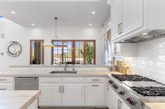 kitchen with light countertops, stainless steel gas cooktop, a sink, and white cabinetry