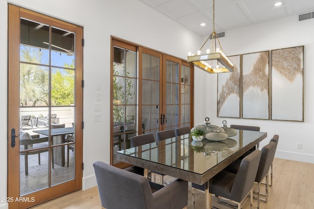 dining area featuring french doors, light wood-type flooring, visible vents, and baseboards