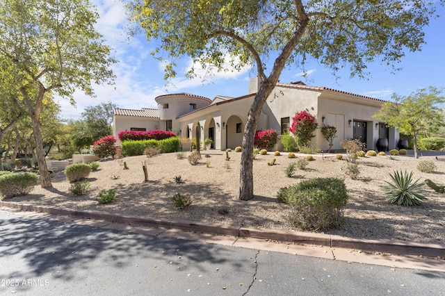 mediterranean / spanish home with a tile roof and stucco siding