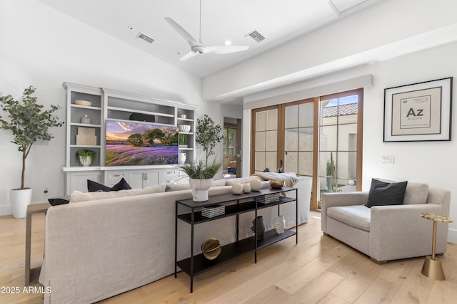 sitting room featuring lofted ceiling, light wood-style floors, visible vents, and a ceiling fan