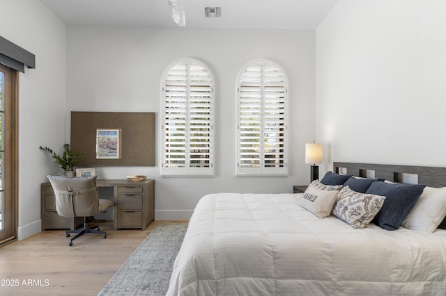 bedroom with light wood-style flooring, visible vents, and baseboards