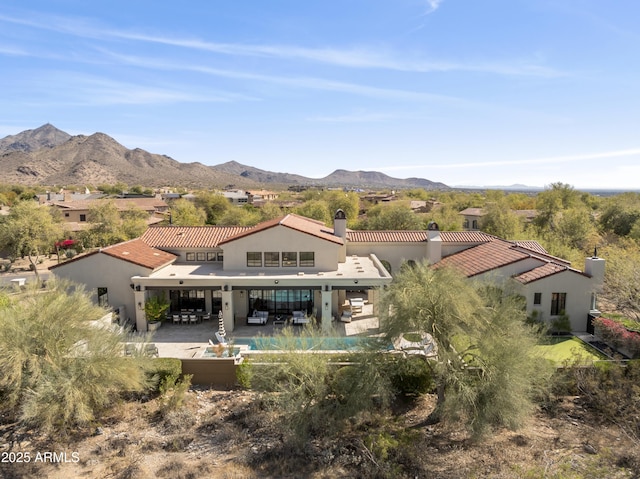 back of property with a mountain view, a patio, and stucco siding