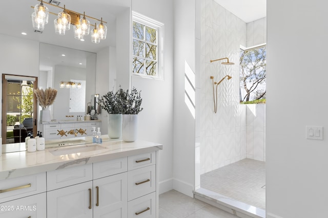 full bath featuring a wealth of natural light, tile patterned flooring, vanity, and walk in shower