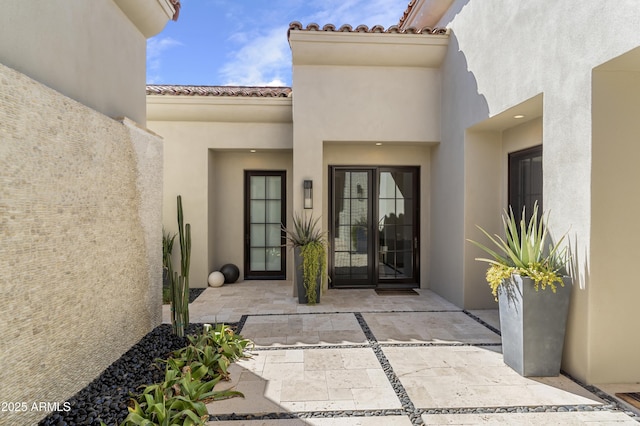 property entrance with a tiled roof and stucco siding