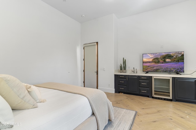 bedroom with beverage cooler, indoor wet bar, and baseboards