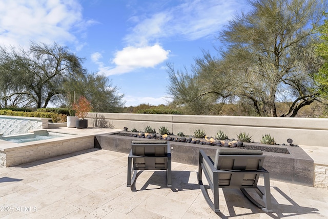 view of patio / terrace with an outdoor fire pit and a hot tub