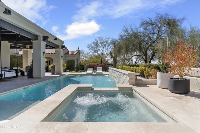 view of swimming pool featuring a pool with connected hot tub and a patio area