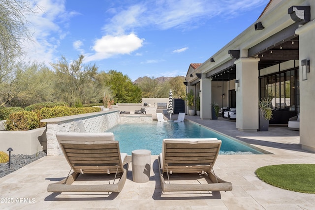 outdoor pool with exterior kitchen and a patio