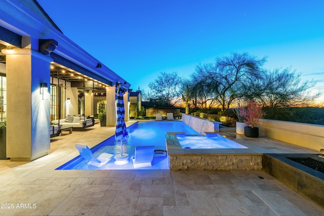 pool at dusk with a fenced in pool, a patio area, an outdoor hangout area, and an in ground hot tub