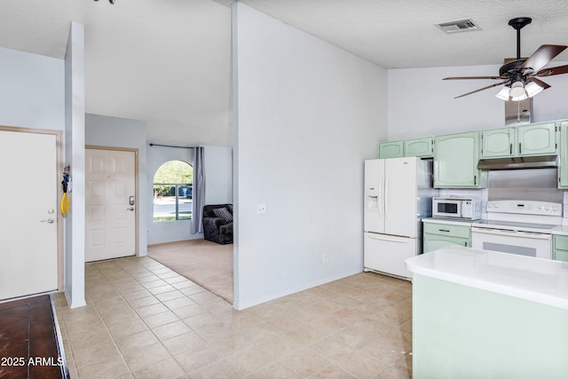 kitchen with green cabinets, a textured ceiling, and white appliances