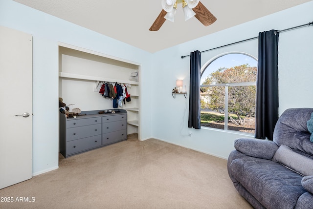 sitting room featuring light colored carpet and ceiling fan