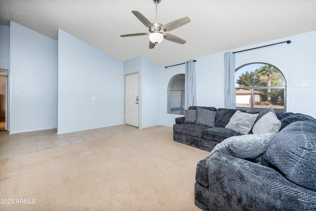 living room featuring ceiling fan, light carpet, and a textured ceiling