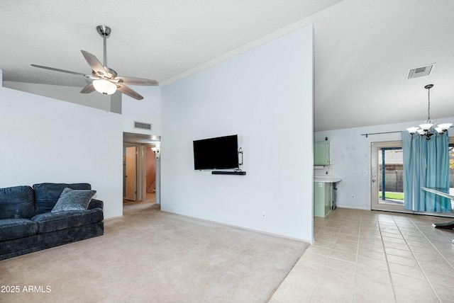 tiled living room featuring vaulted ceiling, ceiling fan with notable chandelier, and a textured ceiling