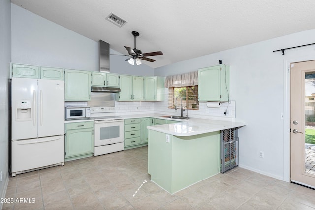 kitchen with lofted ceiling, sink, kitchen peninsula, green cabinets, and white appliances