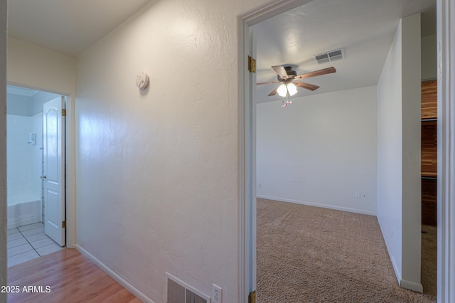 hall with light colored carpet