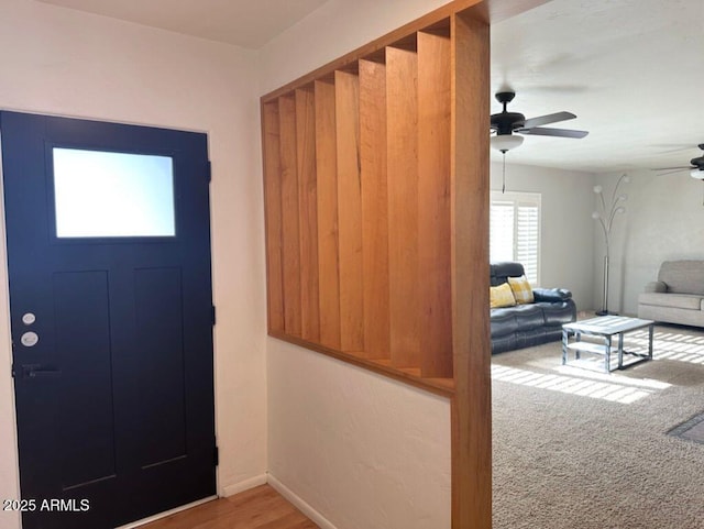 carpeted foyer entrance featuring ceiling fan