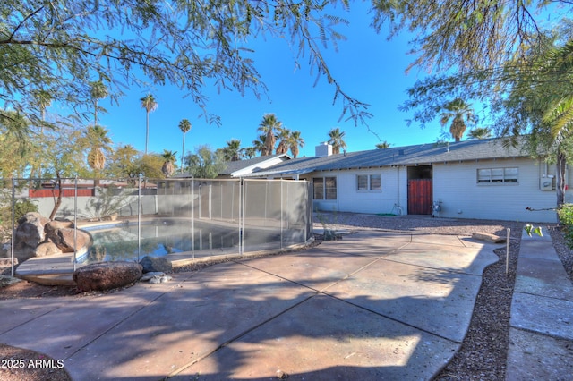 rear view of house with a patio area and a fenced in pool