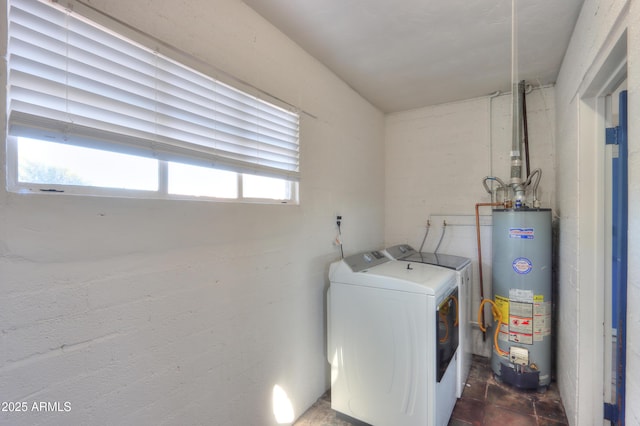 laundry area featuring independent washer and dryer, gas water heater, and a wealth of natural light