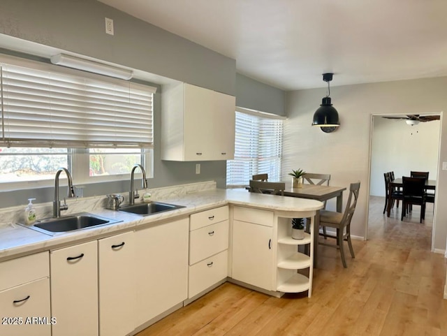 kitchen with pendant lighting, white cabinetry, and sink