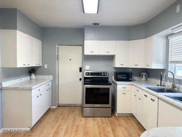 kitchen with stainless steel electric stove, white cabinetry, sink, and light hardwood / wood-style flooring