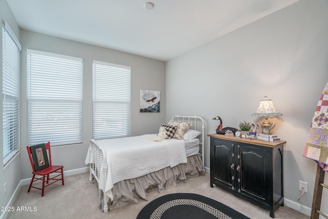 bedroom featuring light colored carpet and baseboards