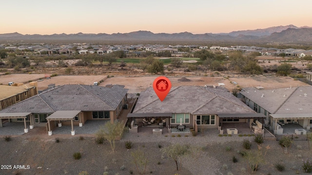 aerial view at dusk featuring a residential view and a mountain view