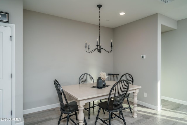 dining room featuring a notable chandelier, recessed lighting, wood finished floors, and baseboards