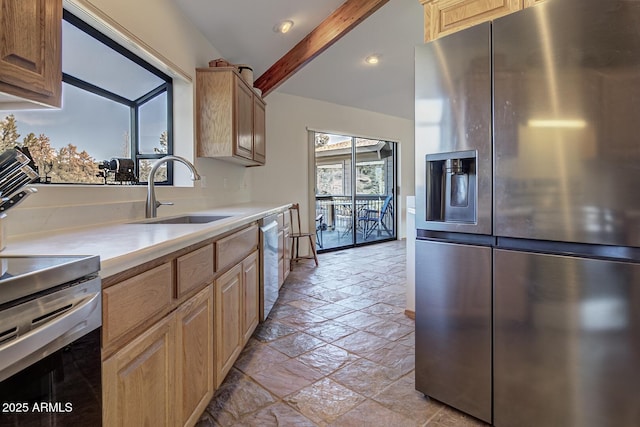 kitchen featuring stone tile floors, appliances with stainless steel finishes, a sink, light countertops, and beam ceiling