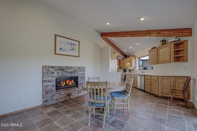 dining space with vaulted ceiling with beams, a stone fireplace, stone finish floor, and recessed lighting