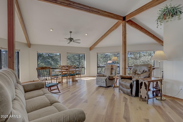 living area with plenty of natural light, lofted ceiling with beams, baseboards, and wood finished floors