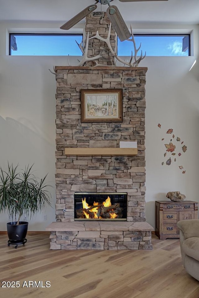 interior space with ceiling fan, a fireplace, and wood finished floors