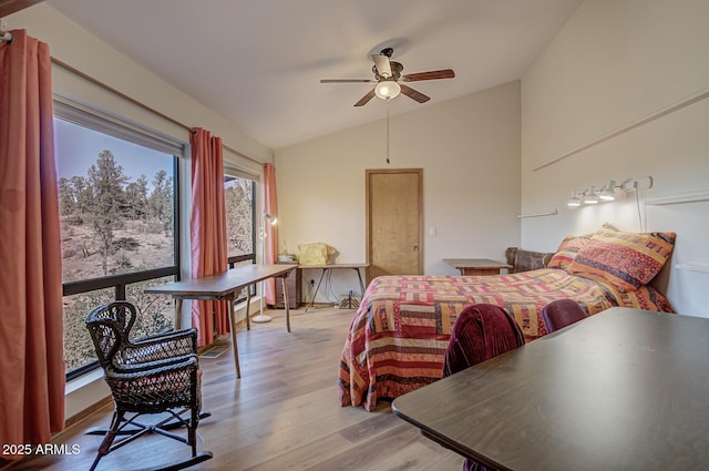 bedroom featuring a ceiling fan, vaulted ceiling, and light wood-style flooring