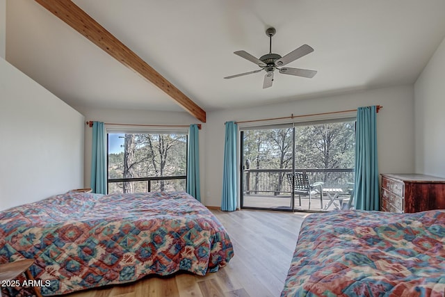 bedroom with access to exterior, beam ceiling, multiple windows, and wood finished floors