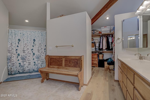 full bathroom with a walk in closet, vaulted ceiling with beams, curtained shower, vanity, and wood finished floors