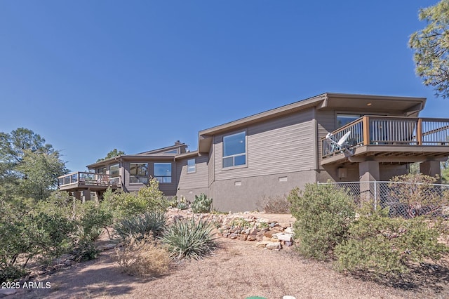 view of front of property with a wooden deck and stucco siding