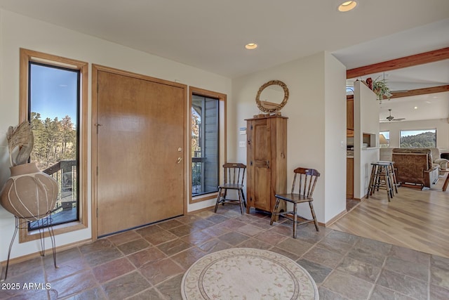 foyer entrance with baseboards, recessed lighting, beam ceiling, and stone tile floors