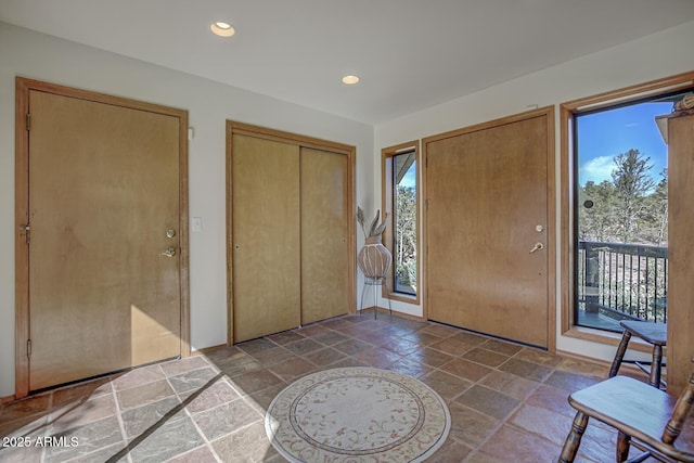 foyer with recessed lighting and stone tile floors