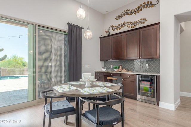 8725 E Menlo Cir, Mesa, AZ 85207 - dining area with wine cooler, light wood-type flooring, and baseboards