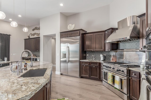8725 E Menlo Cir, Mesa, AZ 85207 - kitchen featuring premium appliances, wall chimney exhaust hood, a sink, backsplash, and recessed lighting
