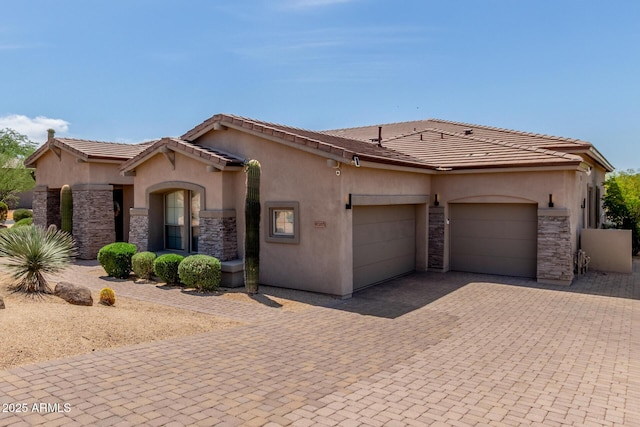 8725 E Menlo Cir, Mesa, AZ 85207 - mediterranean / spanish house featuring stone siding, an attached garage, decorative driveway, and stucco siding