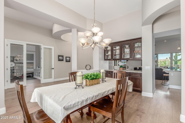 8725 E Menlo Cir, Mesa, AZ 85207 - dining area featuring light wood-type flooring, a chandelier, and baseboards